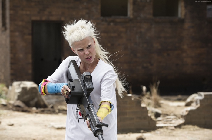 Woman with blonde hair holding a gun