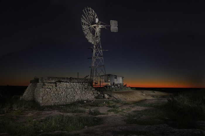 Old windmill and stone structure at night on Nullarbor Plain