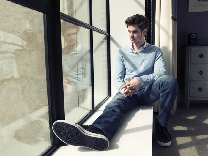 Andrew Garfield sitting by a window