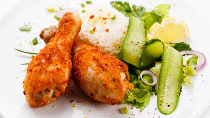 Fried chicken drumsticks with rice and salad