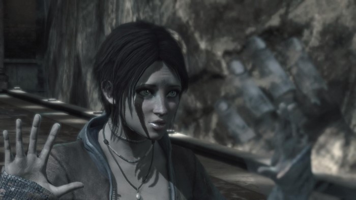 Woman with dark hair and blue eyes in a dark environment