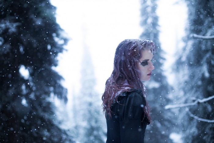 Woman with dark makeup in a snowy forest