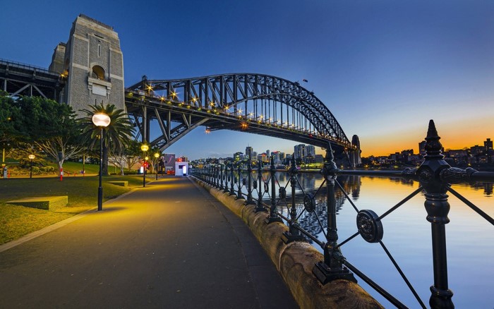 Sydney Harbour Bridge at dusk with city skyline reflection