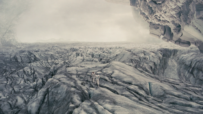 Two astronauts on a desolate icy landscape