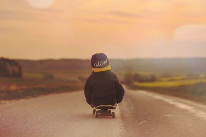 Child on skateboard at sunset