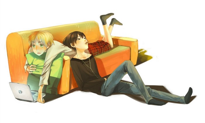 Two boys relaxing on a couch with a laptop