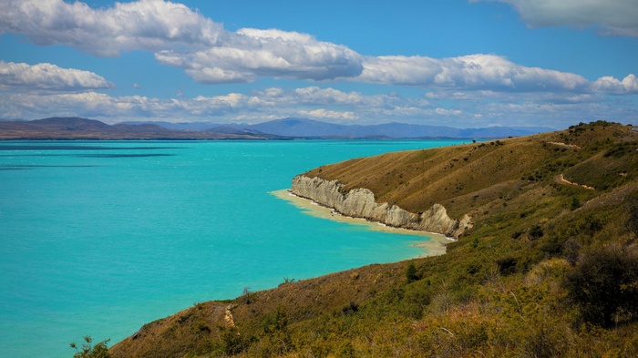 Turquoise lake and rolling hills under a blue sky