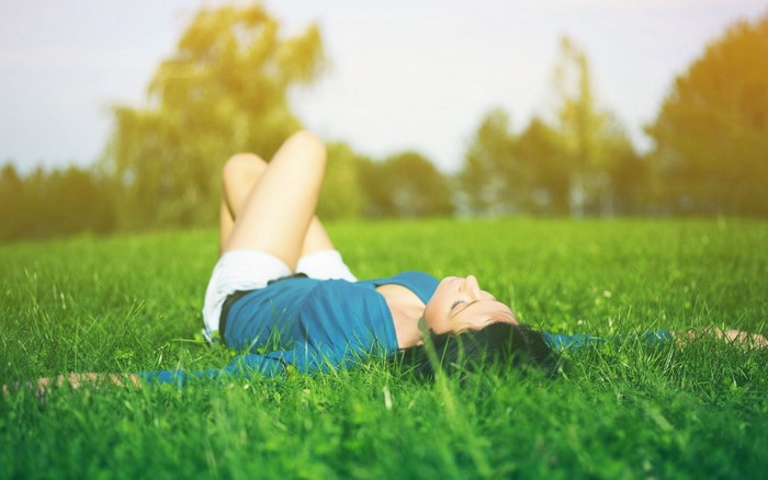 Woman lying on grass in sunlight
