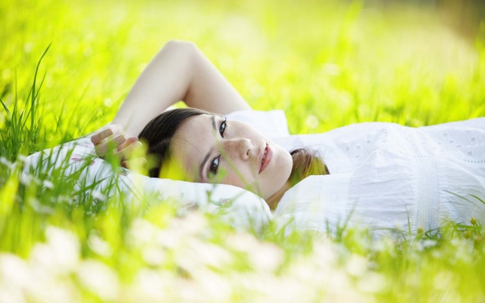 Woman lying in green grass