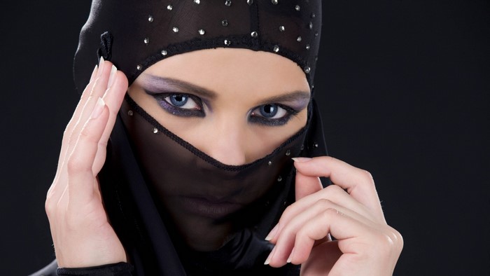 Woman in black veil with blue eyes and makeup