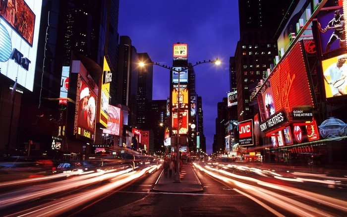 Times Square at night with light trails from traffic