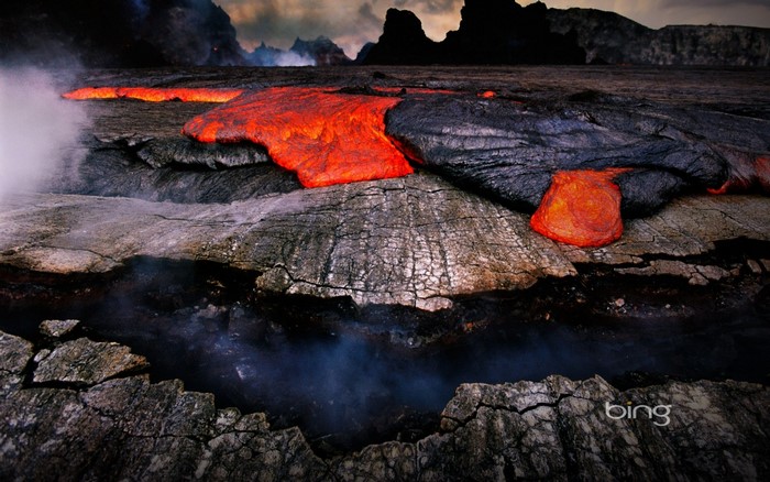Molten lava flows over cracked earth with steam rising