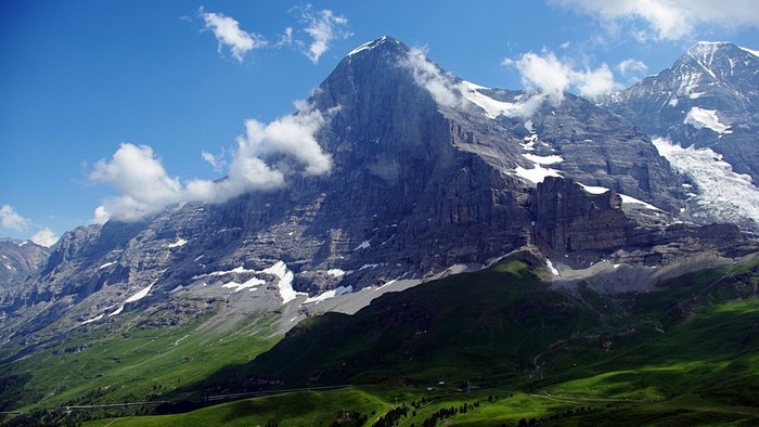 Majestic Alps mountain range under a blue sky with clouds