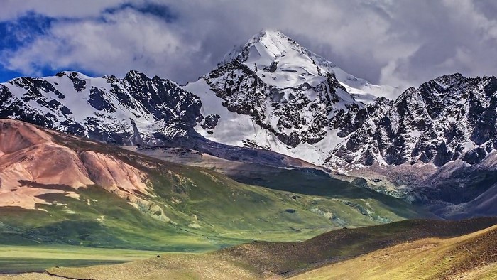 Snow-capped mountains and colorful hills landscape