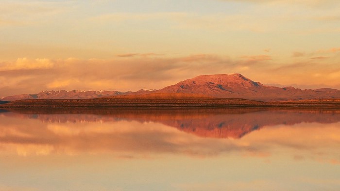 Mountain reflection at sunset over a calm body of water