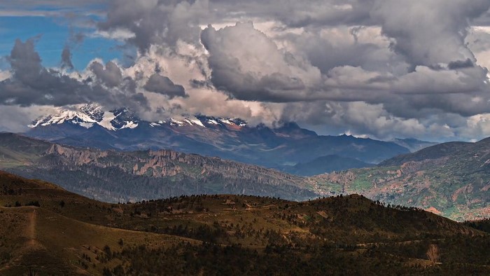 Snow-capped mountains under dramatic clouds