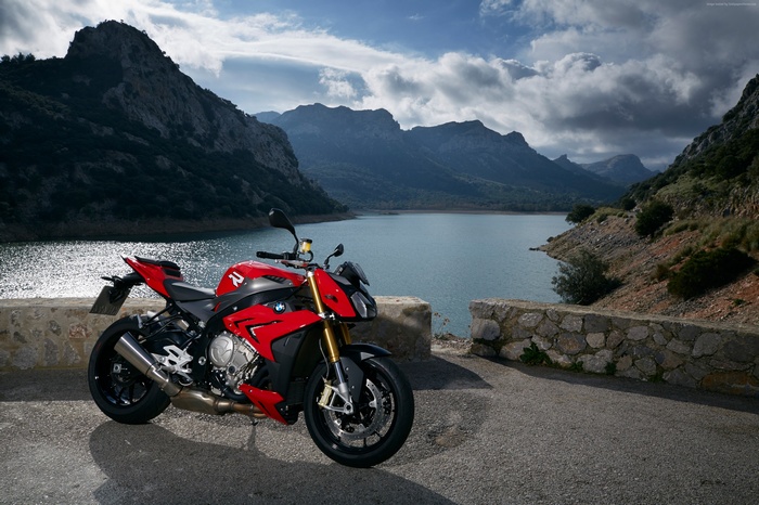 Red BMW S1000R motorcycle parked by a lake