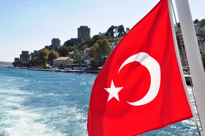 Turkish flag on a boat with Rumeli Hisari fortress