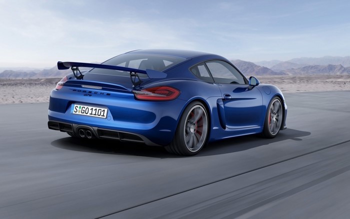 Blue Porsche Cayman GT4 driving on a road