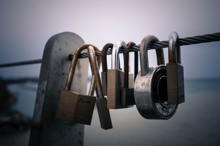 Padlocks on a wire fence with ocean background