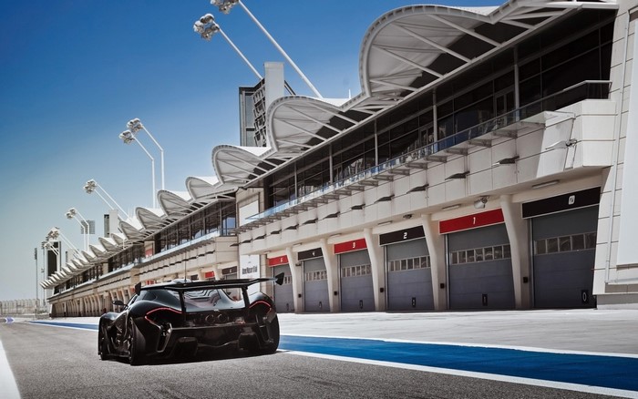 Black McLaren P1 GTR on a race track with grandstands