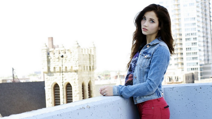 Emily Rudd wearing denim jacket and red pants