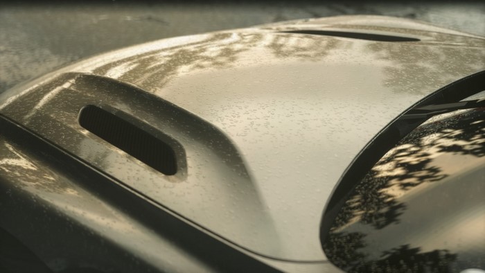 Close up of a car hood with rain drops