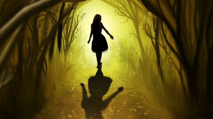 Girl in a dark dress walking in a yellow forest