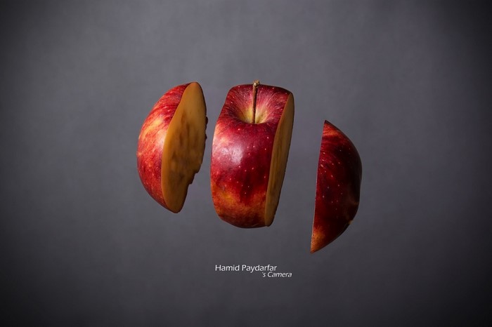 Sliced red apple floating against a dark background