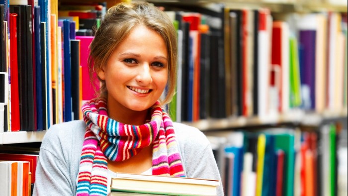 Young woman with books in a library