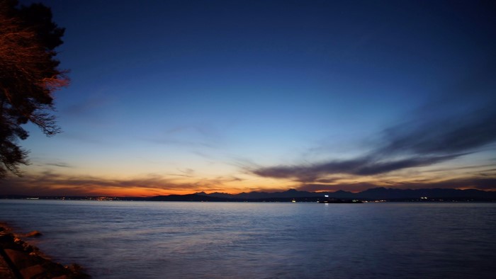 Sunset over the sea with mountains on the horizon