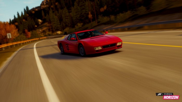 Red Ferrari driving on a winding road in Forza Horizon