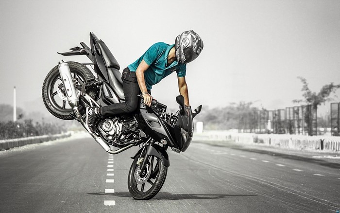 Man performing a wheelie on a motorcycle