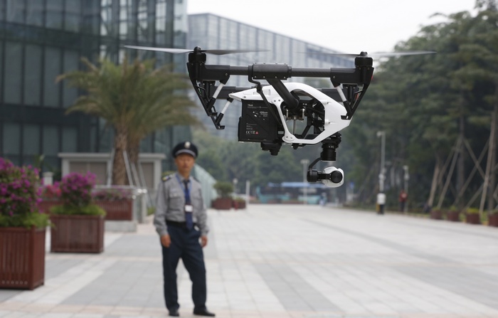 DJI Inspire One drone flying near a security guard