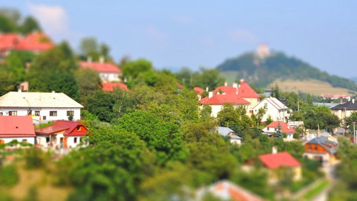Village with red rooftops and castle on hill in Slovakia