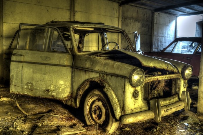 Abandoned vintage car in a derelict garage