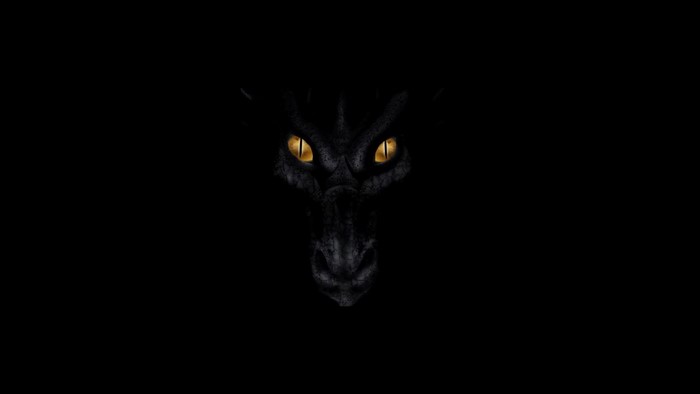 Black dragon face with glowing yellow eyes on black background