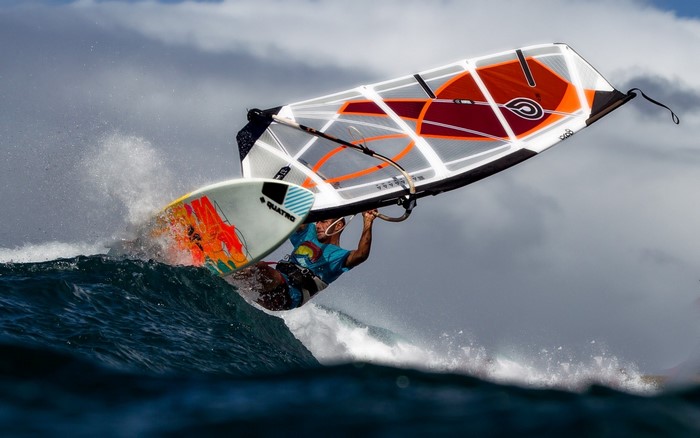 Windsurfer performing a jump over a wave