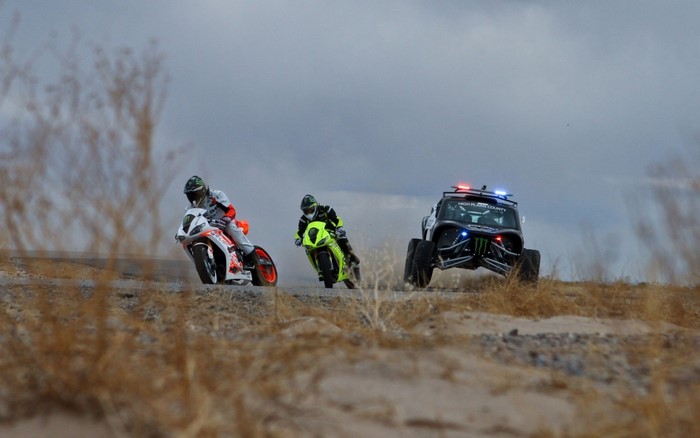 Motorcycles and UTV racing in a desert landscape