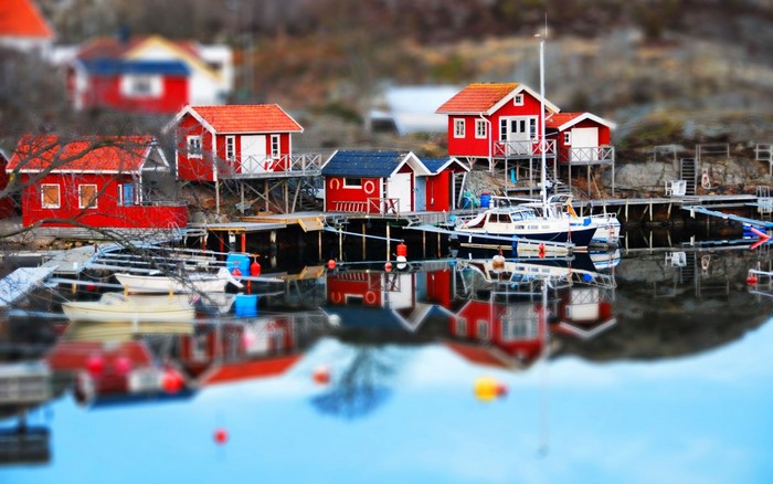 Red houses and boats on a lake with reflections