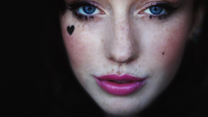 Close up portrait of a woman with blue eyes and freckles