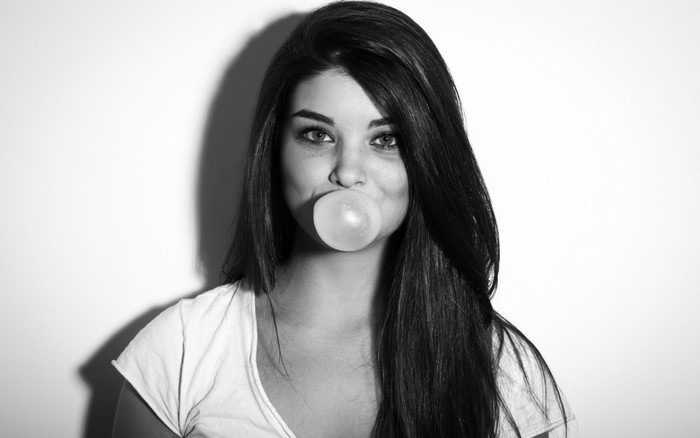 Woman blowing bubble gum in black and white portrait