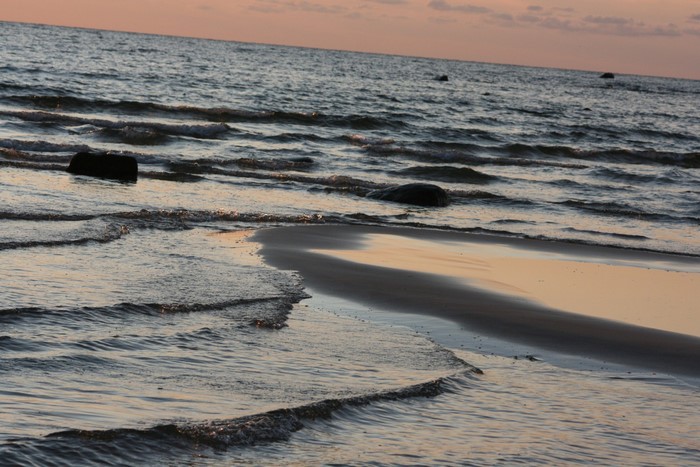 Sunset over the sea with waves and rocks