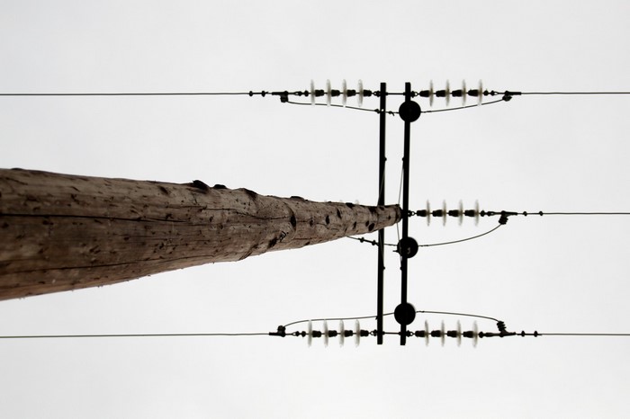 Wooden utility pole with power lines against overcast sky