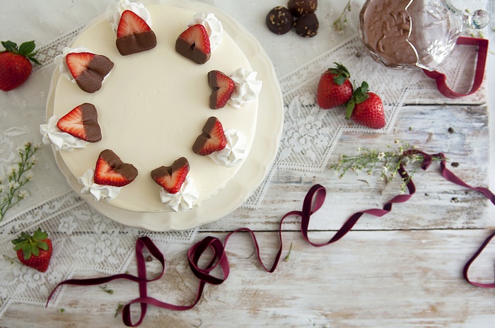 Chocolate-dipped strawberry cake with whipped cream and 'love' ribbon