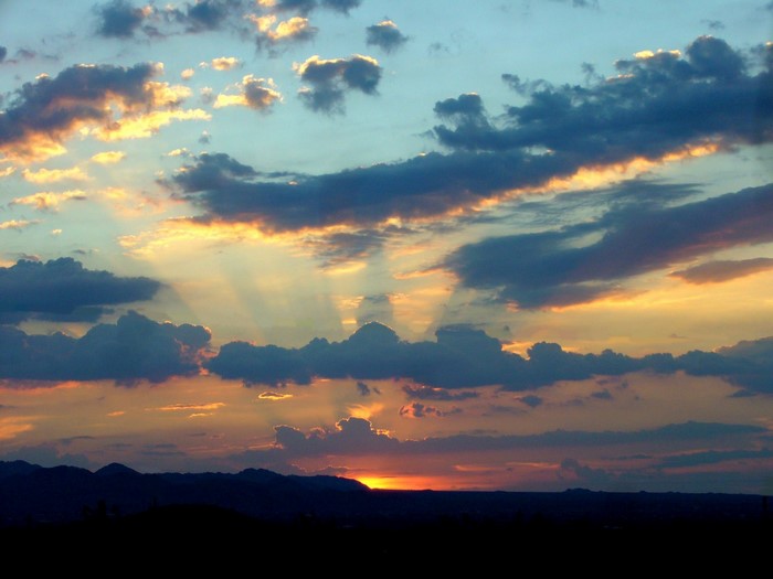 Sunset with sunbeams over mountains
