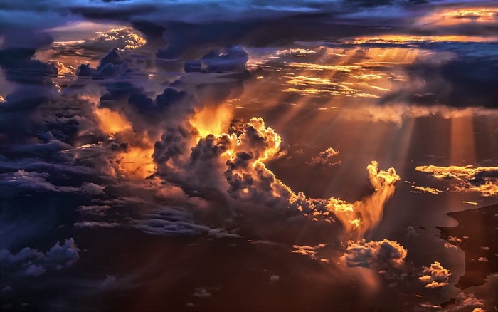 Sunlight beams through dramatic clouds at sunset