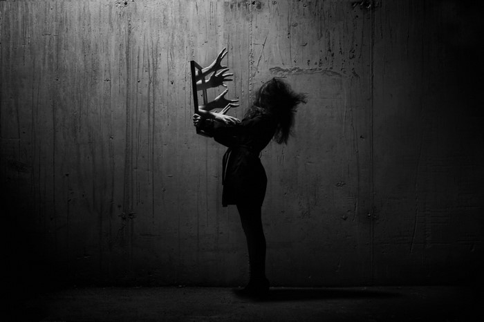 Woman holding a frame with hands reaching out