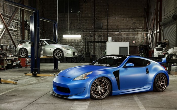 Blue Nissan 370Z and silver Nissan 350Z in a garage
