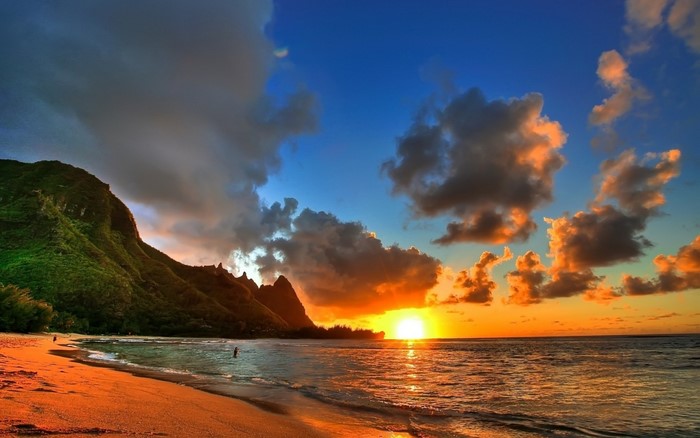 Sunset over a tropical beach with mountains